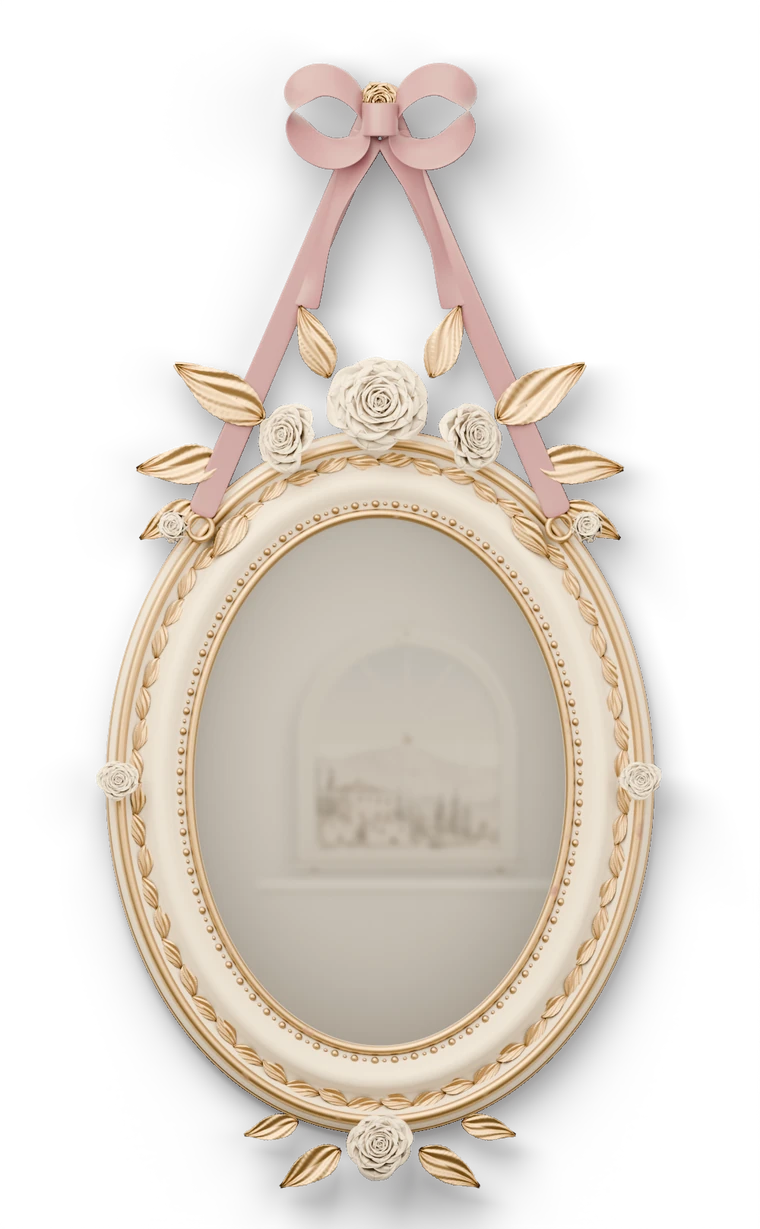 An antique oval wall mirror carved with roses and gilt laurel, hung from a gilt rose on a dusty-rose silk ribbon